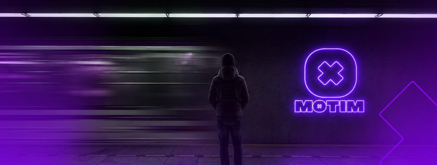 Pessoa numa estação com metrô em movimento e logo neon da Motim ao fundo, iluminando o ambiente.